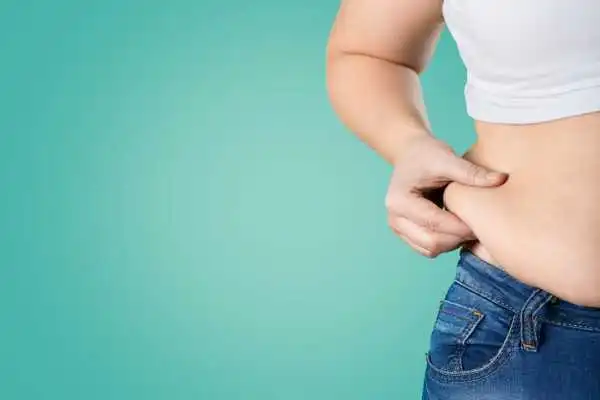Image of woman pinching her love handles to show weight gain Salisbury